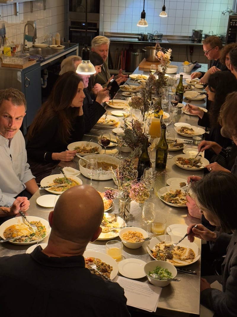 People sitting at a long table with food.